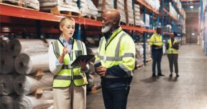 two professionals in safety vests discussing IOS standards